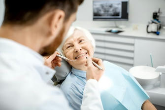 How do seniors apply for the free dental implant program?